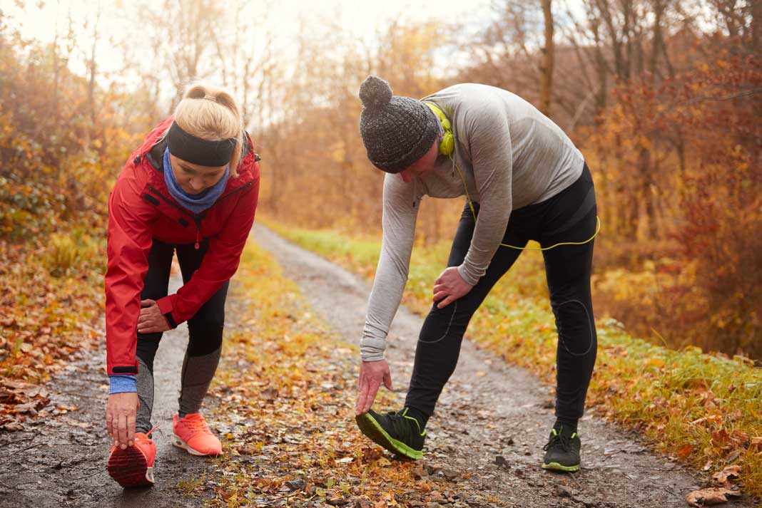 Mature Adult Couple Exercising Together in Fall for Couples Fitness