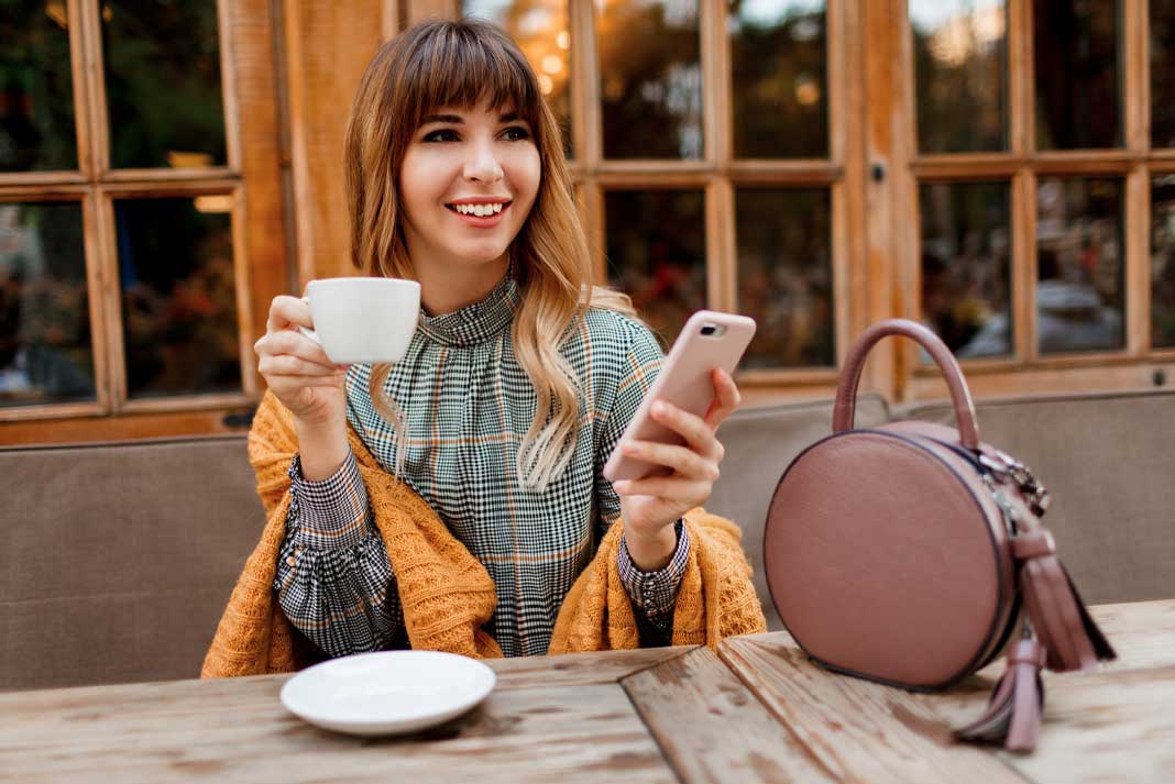 Smiling Carefree Woman Having a Coffee Break to Help Reduce Workday Stress
